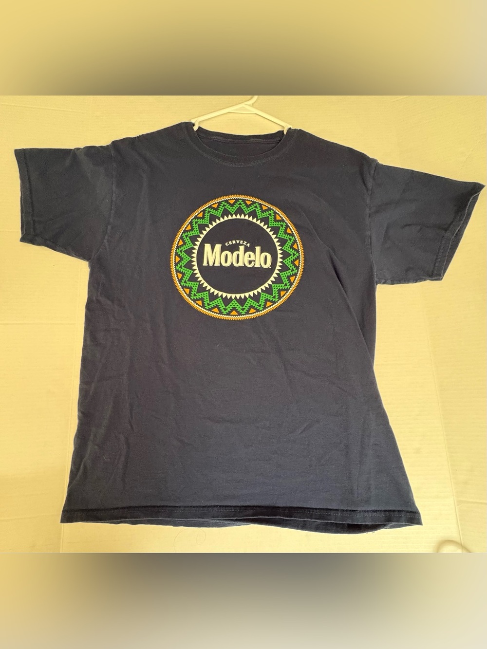 Modelo Blue Short-Sleeve Tee with Green & Yellow Badge